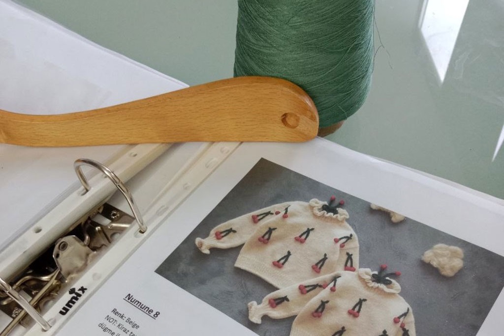 Artisan crafting custom knitwear design in workshop. UBBA Textile